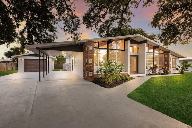 4232 Pandora Rd, Venice, FL 34293 - mid-century home featuring concrete driveway, an attached carport, an outdoor structure, and stucco siding