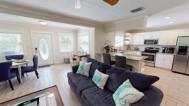 152 Coolidge Dr, Sarasota, FL 34236 - living room featuring crown molding, light wood finished floors, a textured ceiling, and recessed lighting