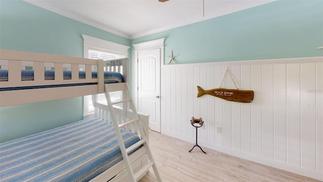 152 Coolidge Dr, Sarasota, FL 34236 - bedroom with light wood-style flooring, a wainscoted wall, and ornamental molding
