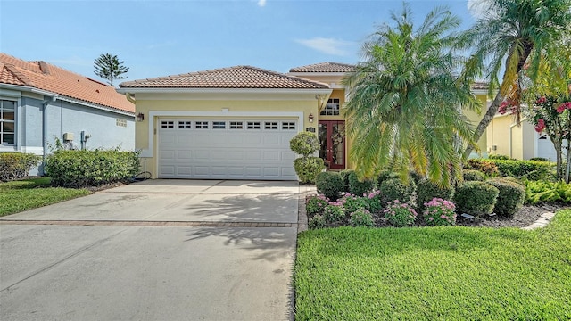 8183 Nice Way, Sarasota, FL 34238 - mediterranean / spanish home featuring an attached garage, driveway, a front lawn, stucco siding, and a tiled roof