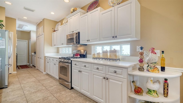 8183 Nice Way, Sarasota, FL 34238 - kitchen with stainless steel appliances, white cabinetry, light countertops, light tile patterned floors, and recessed lighting