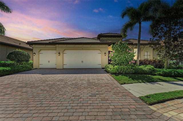 138 Toscavilla Blvd, Nokomis, FL 34275 - mediterranean / spanish home with decorative driveway, stucco siding, an attached garage, and a tile roof