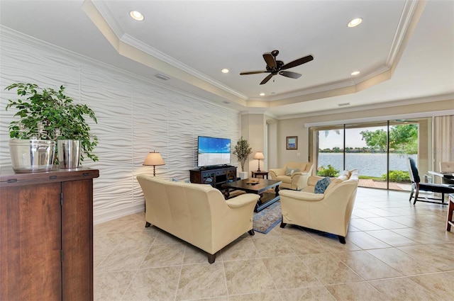 138 Toscavilla Blvd, Nokomis, FL 34275 - living area featuring a raised ceiling, a ceiling fan, light tile patterned floors, an accent wall, and crown molding