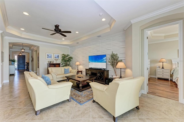 138 Toscavilla Blvd, Nokomis, FL 34275 - living room with a ceiling fan, a raised ceiling, light tile patterned floors, an accent wall, and ornamental molding