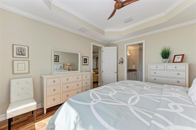 138 Toscavilla Blvd, Nokomis, FL 34275 - bedroom with wood finished floors, crown molding, connected bathroom, a raised ceiling, and ceiling fan