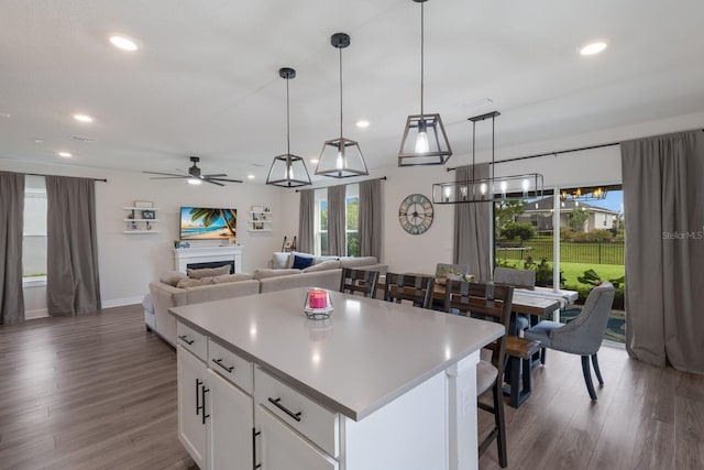 8985 Royal River Cir, Parrish, FL 34219 - kitchen with a ceiling fan, wood finished floors, recessed lighting, a kitchen island, and white cabinets