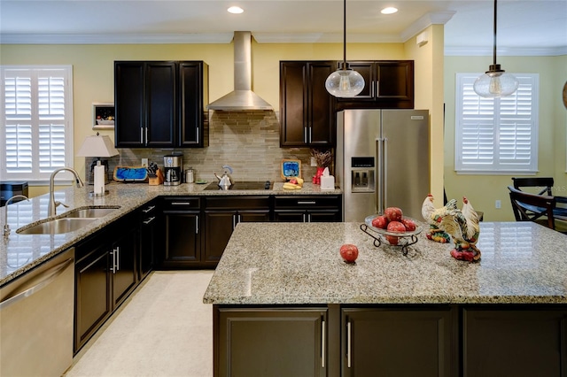 3681 Divot Ln, Sarasota, FL 34232 - kitchen with stainless steel appliances, wall chimney exhaust hood, light stone countertops, hanging light fixtures, and crown molding