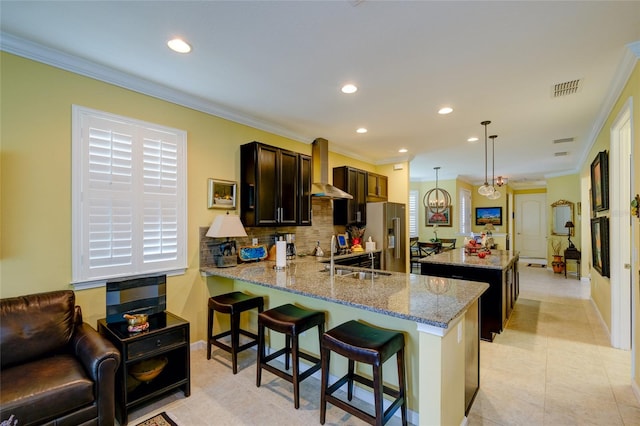 3681 Divot Ln, Sarasota, FL 34232 - kitchen with wall chimney exhaust hood, high end refrigerator, recessed lighting, tasteful backsplash, and dark brown cabinetry