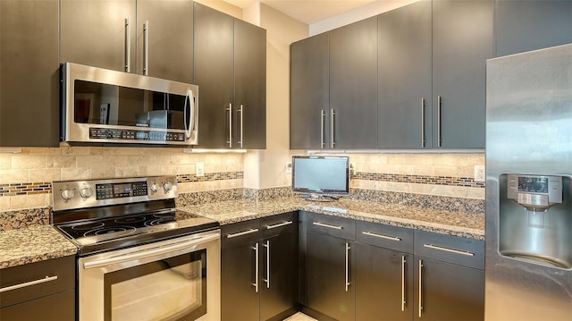 1771 Ringling Blvd Unit 1206, Sarasota, FL 34236 - kitchen featuring appliances with stainless steel finishes, decorative backsplash, light stone counters, and modern cabinets