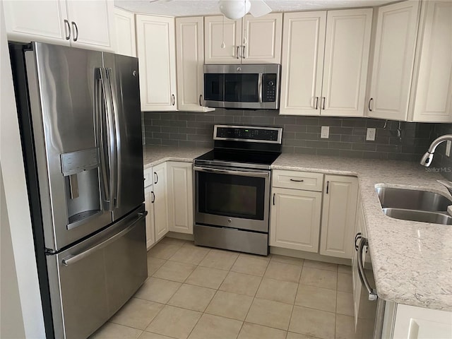 2131 Montclair Dr Unit 2131 & 2137, Sarasota, FL 34231 - kitchen featuring stainless steel appliances, light tile patterned floors, tasteful backsplash, and white cabinetry