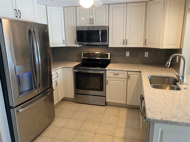 2131 Montclair Dr Unit 2131 & 2137, Sarasota, FL 34231 - kitchen with appliances with stainless steel finishes, decorative backsplash, light tile patterned flooring, and white cabinets