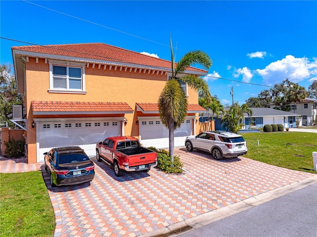 2119-2125 Montclair Dr Unit 2119 & 2125, Sarasota, FL 34231 - mediterranean / spanish house featuring a tiled roof, decorative driveway, stucco siding, a front lawn, and an attached garage
