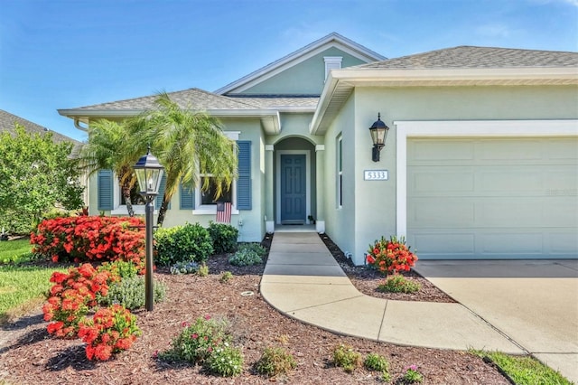 5333 Tide Point Way, Bradenton, FL 34208 - view of front of property featuring stucco siding, an attached garage, and roof with shingles