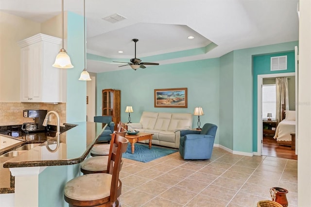 5333 Tide Point Way, Bradenton, FL 34208 - living room with light tile patterned flooring, a tray ceiling, ceiling fan, recessed lighting, and crown molding