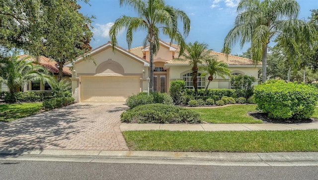 7717 US Open Loop, Lakewood Ranch, FL 34202 - mediterranean / spanish-style house with stucco siding, an attached garage, decorative driveway, and a tile roof