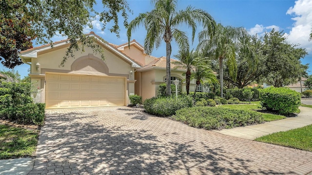 7717 US Open Loop, Lakewood Ranch, FL 34202 - mediterranean / spanish house featuring stucco siding, decorative driveway, and an attached garage