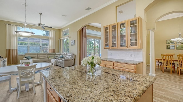 7717 US Open Loop, Lakewood Ranch, FL 34202 - kitchen with arched walkways, ceiling fan, ornamental molding, light wood-style flooring, and light stone countertops