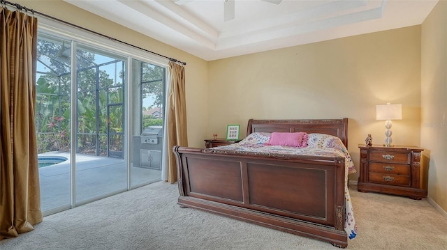 7717 US Open Loop, Lakewood Ranch, FL 34202 - bedroom with carpet flooring, access to exterior, a tray ceiling, and a ceiling fan