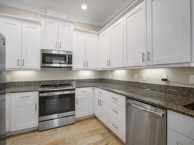 7840 34th Ave W Unit 303, Bradenton, FL 34209 - kitchen featuring stainless steel appliances, light wood-type flooring, recessed lighting, white cabinetry, and dark stone counters