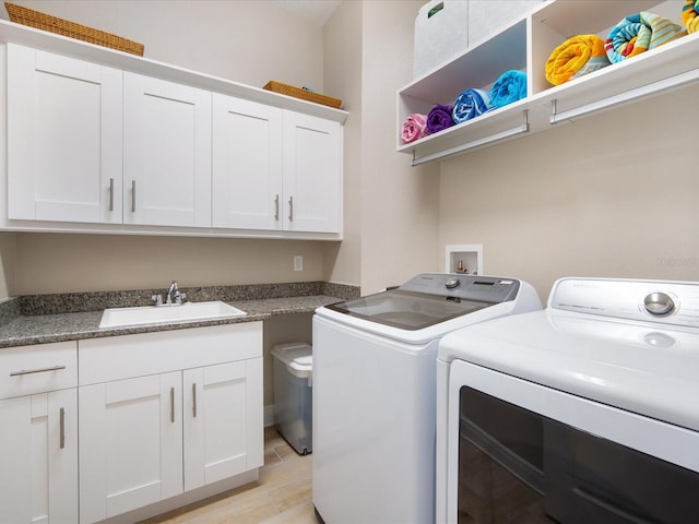 7840 34th Ave W Unit 303, Bradenton, FL 34209 - washroom featuring separate washer and dryer, light wood-style flooring, and cabinet space