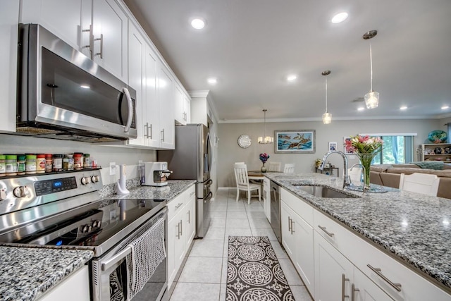 640 Encarnacion St, Punta Gorda, FL 33983 - kitchen featuring appliances with stainless steel finishes, crown molding, white cabinets, decorative light fixtures, and light stone countertops