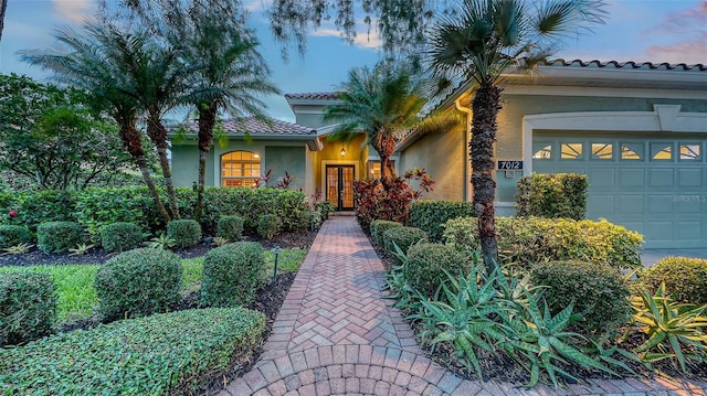 7012 Treymore Ct, Sarasota, FL 34243 - view of front of home featuring an attached garage, stucco siding, and a tile roof