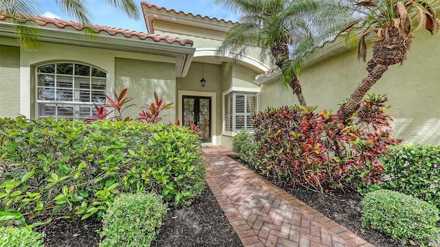 7012 Treymore Ct, Sarasota, FL 34243 - view of exterior entry with french doors, stucco siding, and a tiled roof
