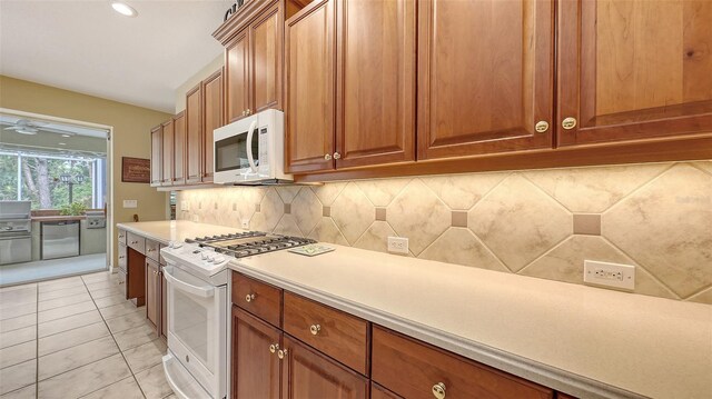 7012 Treymore Ct, Sarasota, FL 34243 - kitchen featuring white appliances, backsplash, light countertops, brown cabinets, and recessed lighting