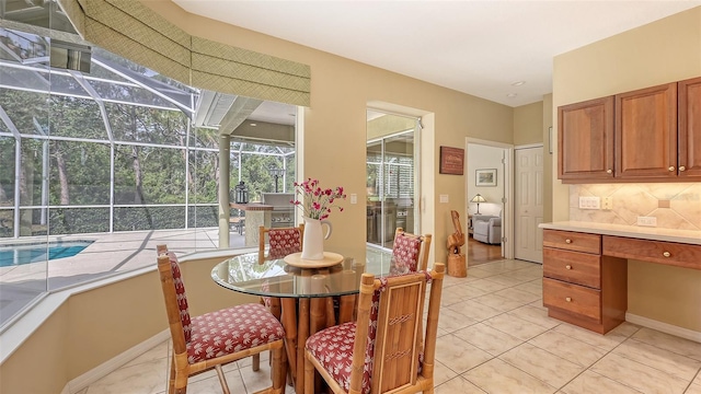 7012 Treymore Ct, Sarasota, FL 34243 - dining room featuring a sunroom, light tile patterned floors, and built in desk