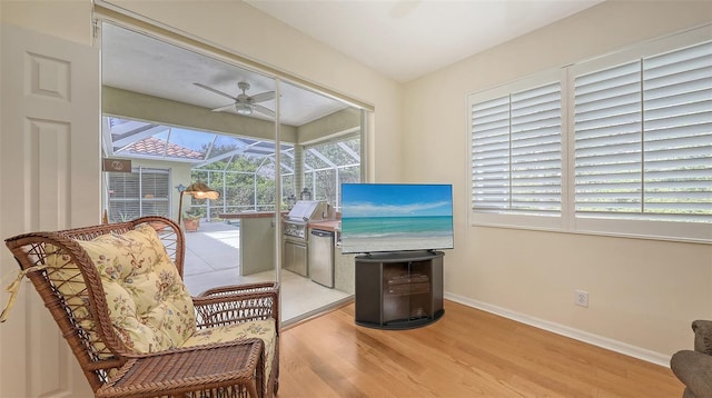 7012 Treymore Ct, Sarasota, FL 34243 - sitting room featuring a ceiling fan, a sunroom, wood finished floors, and plenty of natural light