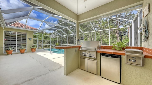 7012 Treymore Ct, Sarasota, FL 34243 - view of patio with exterior kitchen, a lanai, an outdoor pool, and a ceiling fan