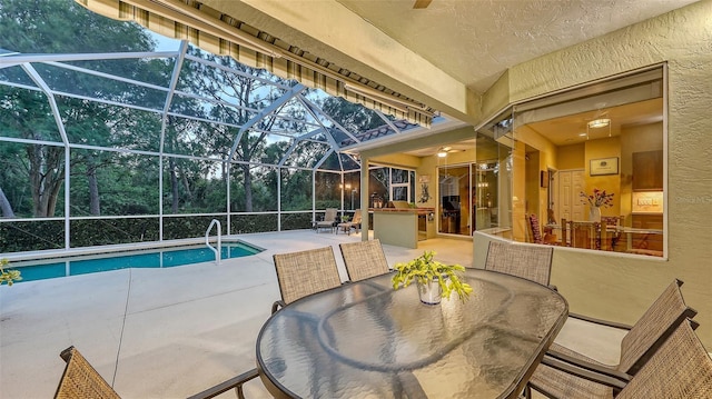 7012 Treymore Ct, Sarasota, FL 34243 - outdoor pool with a patio area, outdoor dining area, glass enclosure, exterior kitchen, and a ceiling fan