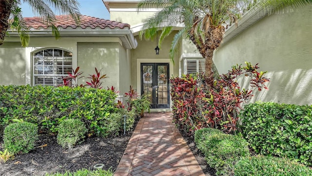 7012 Treymore Ct, Sarasota, FL 34243 - view of exterior entry with french doors, stucco siding, and a tile roof
