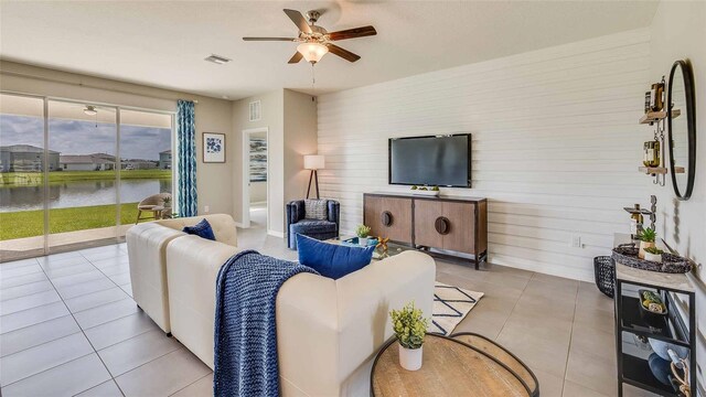 12043 Kingsley Trl, Parrish, FL 34219 - tiled living room featuring ceiling fan, a water view, and wooden walls