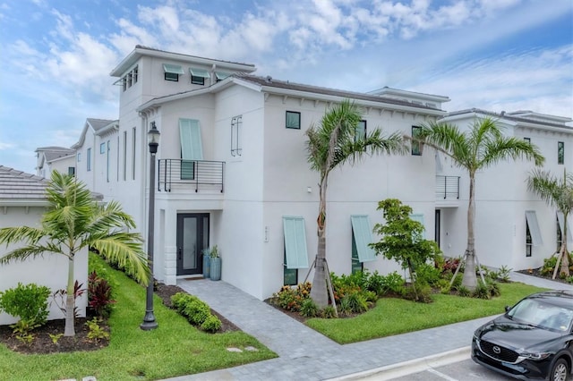 6028 Red Mangrove Ln, Bradenton, FL 34210 - view of front of home with stucco siding, a balcony, and uncovered parking