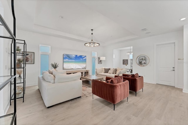 6028 Red Mangrove Ln, Bradenton, FL 34210 - living area with a tray ceiling, a chandelier, and light wood-type flooring
