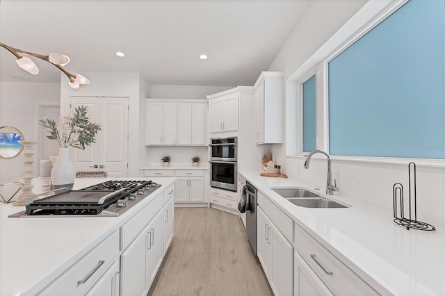 6028 Red Mangrove Ln, Bradenton, FL 34210 - kitchen featuring stainless steel appliances, light countertops, white cabinets, light wood-style flooring, and recessed lighting