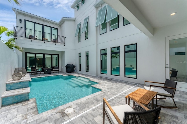 6028 Red Mangrove Ln, Bradenton, FL 34210 - rear view of property featuring a balcony, stucco siding, an outdoor pool, a patio, and an outdoor living space