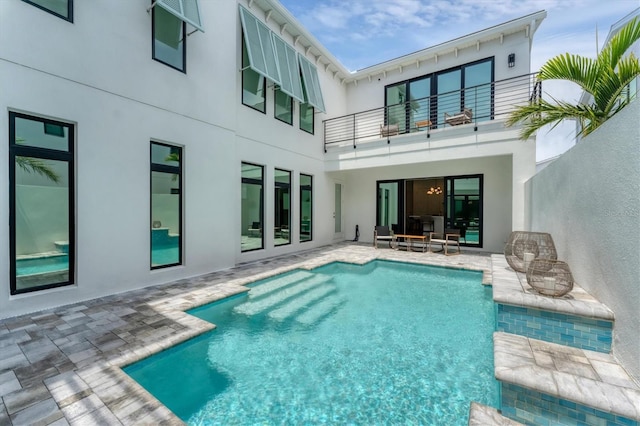 6028 Red Mangrove Ln, Bradenton, FL 34210 - rear view of house with a balcony, stucco siding, a patio area, and an outdoor pool