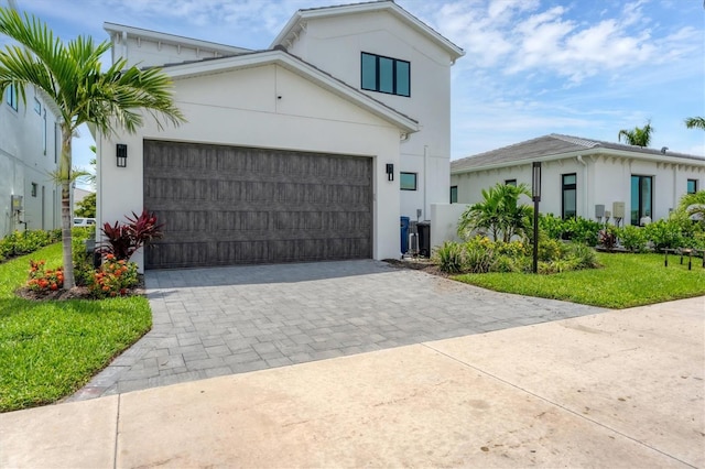6028 Red Mangrove Ln, Bradenton, FL 34210 - view of front facade featuring stucco siding, decorative driveway, a front yard, and an attached garage