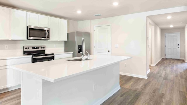 12071 Mountain Island Trl, Parrish, FL 34219 - kitchen with appliances with stainless steel finishes, light wood finished floors, white cabinets, an island with sink, and recessed lighting