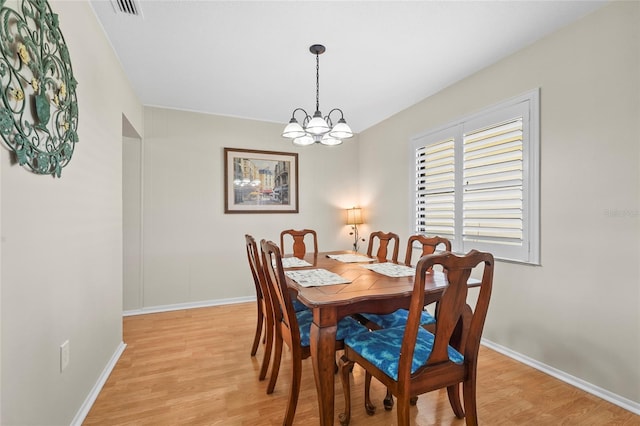 409 Archibald Ave, Sarasota, FL 34243 - dining room with a chandelier and light wood-style flooring