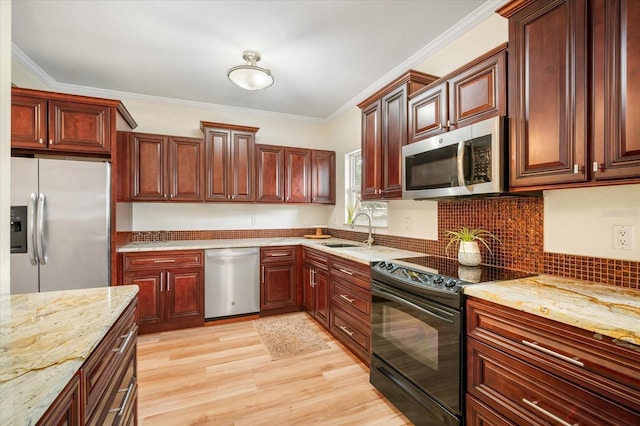520 27th St W, Bradenton, FL 34205 - kitchen with stainless steel appliances, light wood finished floors, light stone countertops, ornamental molding, and backsplash