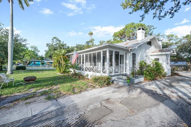 520 27th St W, Bradenton, FL 34205 - view of front of house featuring a sunroom, a fire pit, and a chimney