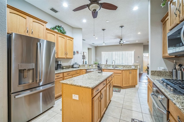 3041 Stonegate Falls Dr, Land O Lakes, FL 34638 - kitchen featuring appliances with stainless steel finishes, a ceiling fan, a peninsula, a kitchen island, and a textured ceiling