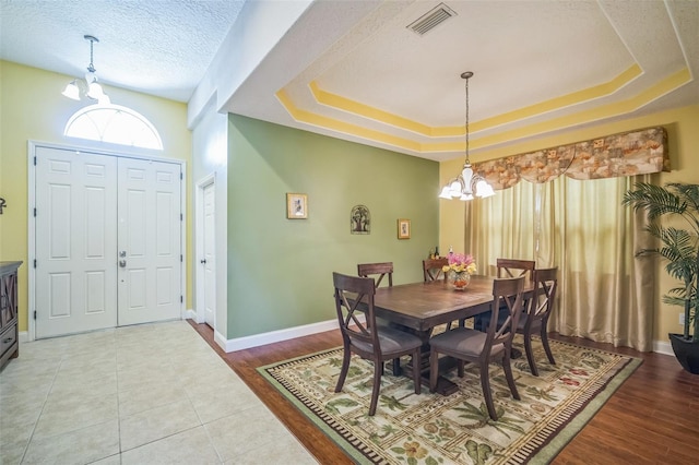 3041 Stonegate Falls Dr, Land O Lakes, FL 34638 - dining room with a chandelier, a raised ceiling, and wood finished floors