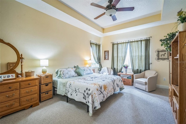 3041 Stonegate Falls Dr, Land O Lakes, FL 34638 - bedroom featuring light colored carpet, a tray ceiling, a ceiling fan, and a textured ceiling
