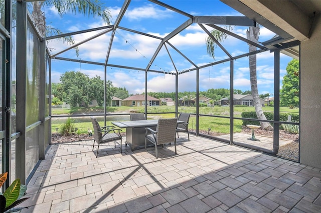 3041 Stonegate Falls Dr, Land O Lakes, FL 34638 - view of patio / terrace with outdoor dining area, glass enclosure, and a residential view