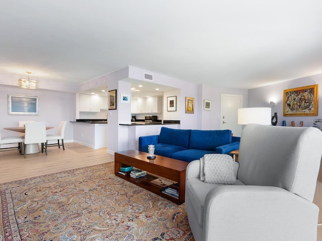2295 Gulf Of Mexico Dr Unit 64S, Longboat Key, FL 34228 - living room with light wood-type flooring, a baseboard heating unit, and a chandelier