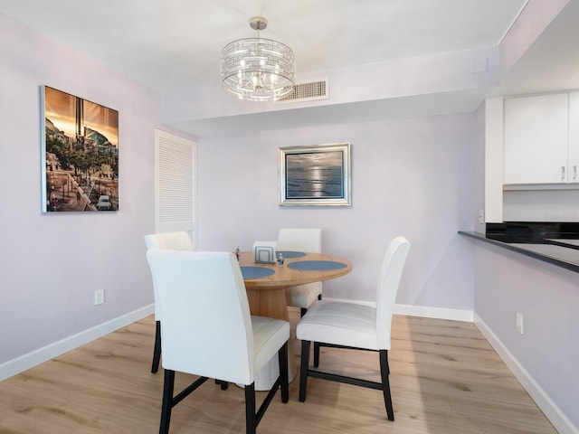 2295 Gulf Of Mexico Dr Unit 64S, Longboat Key, FL 34228 - dining area featuring light wood finished floors and a chandelier